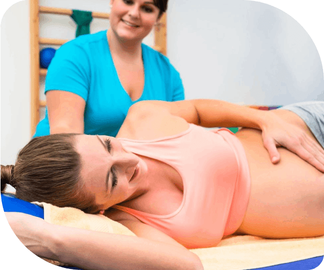 A woman giving pregnancy service to another woman lying on the bed